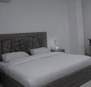 瓦迪穆萨Petra Gardens的卧室配有一张带白色床单和枕头的大床。