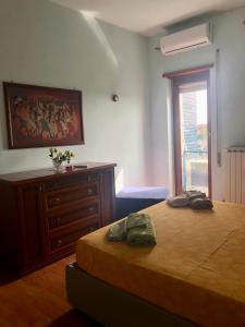罗马MomòHouse - 4 ospiti 2 camere WiFi A/C的一间卧室配有一张床、一个梳妆台和一扇窗户。