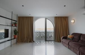 圣保罗湾城VILLA JOSEPH的带沙发和大窗户的客厅