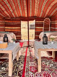 Authentic Desert Camp的帐篷内带两张床和桌子的房间