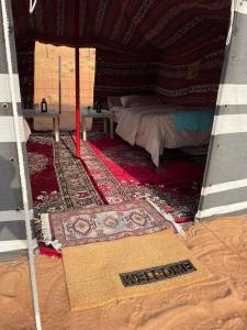 Authentic Desert Camp的一间帐篷内带一张床和地毯的房间