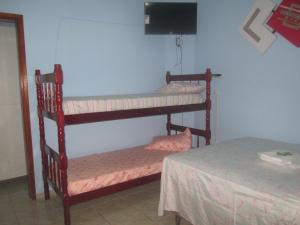 波苏斯-迪卡尔达斯Recanto das Rosas的客房设有两张双层床和一张桌子。