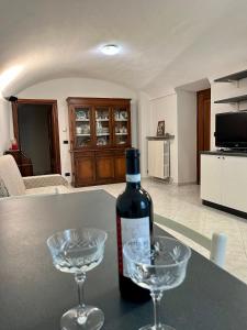 Chiusa di PesioCasa dell’Annunziata的桌子上放有一瓶葡萄酒和两杯酒