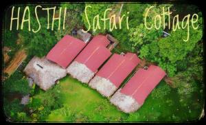 达瓦拉维Hasthi Safari Cottage的享有粉红色屋顶房屋的顶部景色