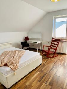 新松奇Komfortowy pokój dla dwojga z balkonem Marcinkowicka的一间卧室配有一张床、一张桌子和一把椅子