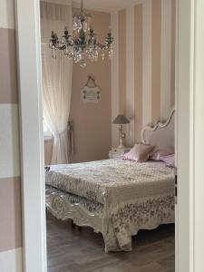 斯培西亚Annali Casa vacanze - Shabby style nella natura的一间卧室配有一张床和一个吊灯
