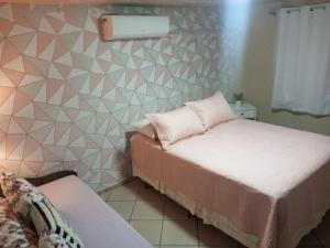 布卢梅瑙Pousada da Alê的一间卧室设有两张床,墙上设有三角形。