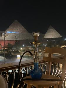 开罗Unique Pyramids View INN的金字塔阳台桌子上的蓝色花瓶