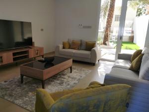Bawsharفيلا مسقط - Muscat Villa的带沙发和平面电视的客厅