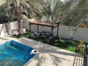 Bawsharفيلا مسقط - Muscat Villa的后院设有游泳池和凉亭