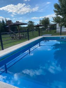 巴拉德罗Los Talares的蓝色游泳池,后面设有野餐桌