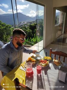 伊比科阿拉Hotel Raio do Sol的坐在餐桌上吃一盘食物的人