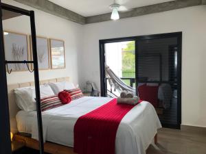 波苏斯-迪卡尔达斯Uai House com jacuzzi (Espaço romântico)的一间卧室配有一张床铺,床上铺有红色毯子