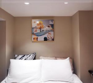 多伦多toronto midtown spacious room的卧室配有一张白色床,墙上挂有绘画作品