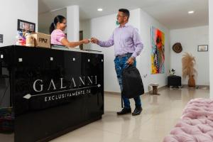 巴耶杜帕尔Hotel Galanni的男人和女人在商店里摇手