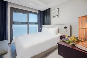 釜山NewCZ Osiria Residence的卧室设有一张白色大床和一扇窗户。