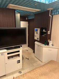 横滨Hotel AKAIKUTSU - Adult Only的客厅配有大屏幕平面电视