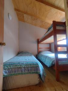 PueloCabaña Don Maxi的一间卧室设有两张双层床和梯子