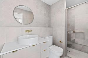 巴特曼斯贝Ohana Apartments 103的一间带水槽、卫生间和镜子的浴室