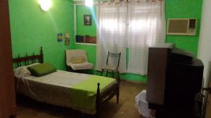 圣米格尔·德·图库玛La Cage的一间卧室设有一张床和绿色的墙壁