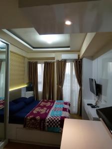 日惹Apartemen Malioboro city by Ameliarooms的一间卧室配有一张床和一台电视