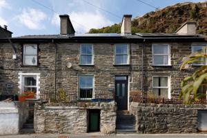 TanygrisiauCosy, 2-bedroom Snowdonia cottage mountain retreat的山前的古老石屋