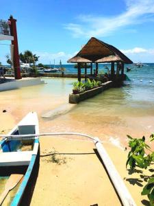 Lapu Lapu CityPRIVATE COLLECTION 贅沢 Jade's Beach Villa 별장 Cebu-Olango An exclusive private beach secret的船绑在码头上,在水中建了一座建筑物