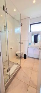 巴利托Zimbali Lakes Boulevard Suites的一间带玻璃淋浴和卫生间的浴室