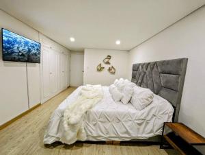 波哥大CHARMING APARTMENT IN CHICO RESERVED, 93 PARK, ZONE T!的一间卧室配有一张带白色床单的大床