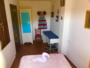格拉纳达CUEVA EL DUENDE的一间设有两张床、一张桌子和一把椅子的房间