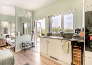 马诺比尔Calvesland Hideaway的厨房设有绿色的墙壁、窗户和水槽