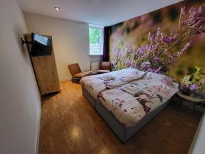 伊科斯特Herberg De Eexter Os的一间卧室配有一张床、一台电视和鲜花