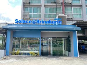 曼那Solace at Srinakarin Hotel的蓝色的建筑,上面有标志