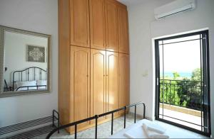 埃雷特里亚Άνετο διαμέρισμα για 4 με θέα的一间卧室设有木制橱柜和大窗户