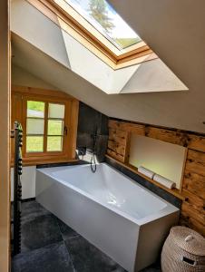 DiemtigenChalet Grittelihus, large bathroom, Lots of living space, nahe Interlaken的浴室配有大型白色浴缸,设有天窗