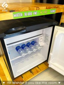 岘港FSTAY - COZY AND PEACEFUL HOMESTAY DA NANG的配有瓶装水的开放式冰箱