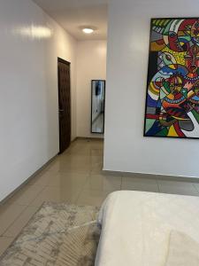 拉各斯Guided Hospitality - Luxury Accommodations的一间设有一张床的客房,墙上挂着一幅画