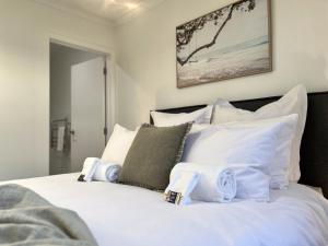 汉密尔顿Villa in Central Hamilton - By KOSH BNB的卧室配有白色的床铺和白色的枕头