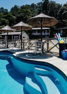 科罗曼德镇安克尔汽车旅馆的甲板上配有椅子和遮阳伞的游泳池