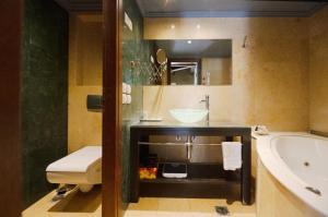 罗希姆诺Civitas Suites Hotel的带浴缸、水槽和浴缸的浴室