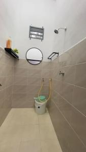 大山脚Tok Abah Homestay Bukit Mertajam的浴室设有卫生间和墙上的镜子。