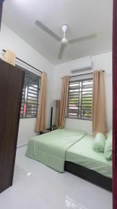 大山脚Tok Abah Homestay Bukit Mertajam的一间卧室设有一张绿色的床和一个窗户。
