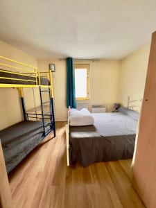 拉姆吉La Mongie - Apt 2 ch - 8 pers - Place parking couvert的一间卧室设有两张双层床,铺有木地板。