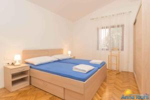 奈维斯Apartment in Njivice/Insel Krk 27855的一间卧室配有一张带蓝色床单的床和一扇窗户。