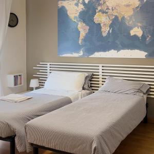 拉奎拉Le stanze di Adele的卧室内的两张床,墙上有地图