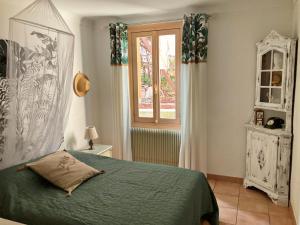 尼斯Douceur d'Azur的一间卧室设有一张绿色的床和一个窗户。