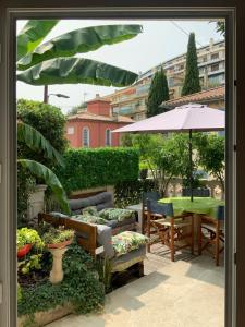 尼斯Douceur d'Azur的庭院配有桌椅和遮阳伞。