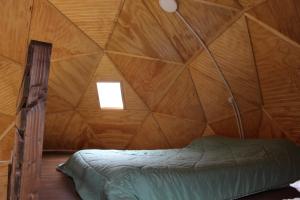 科伊艾科Lerun Sheg Lodge的木制客房内的一间卧室,配有一张床