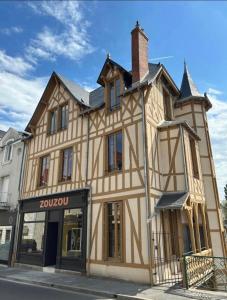 维耶尔宗La Maison à Pan De Bois Chambre Napoléon III的城市街道上一座大型建筑,设有商店