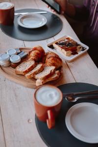 圣卡洛斯-德巴里洛切半岛贝提酒店的一张桌子,上面放着一盘面包和咖啡
